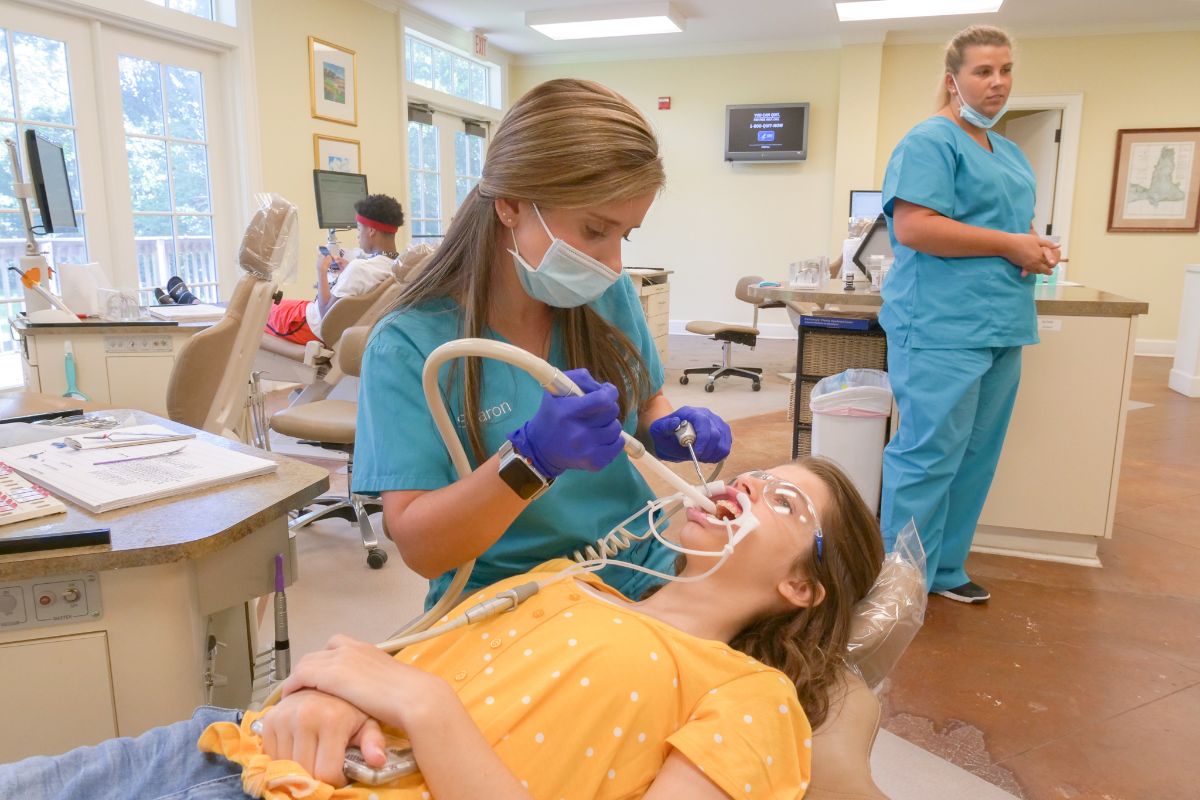 assistant working on a patient's teeth